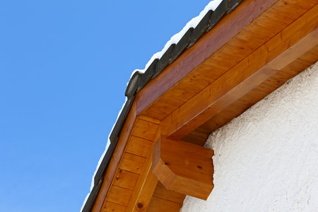 New roof top detail with ceramic tiles with snow against blue skies