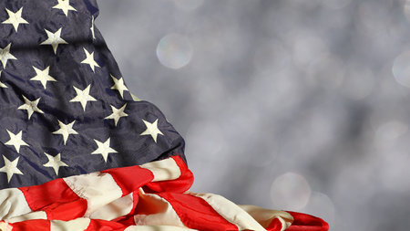Rippled american flag against blurred sparkling background with space for copy
