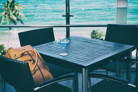 Travel bag on a chair in a coffee shopの写真素材