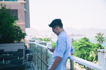 Young man dressed formal resting at office balcony.の写真素材