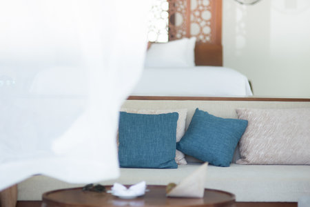 white sofa with two blue pillows  isolated on white backgroundの写真素材