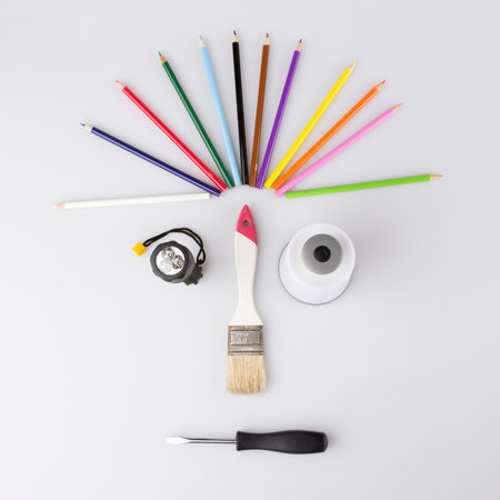 Desk of an artist with lots of stationery objects. Studio shot on wooden background, and funny face.の写真素材