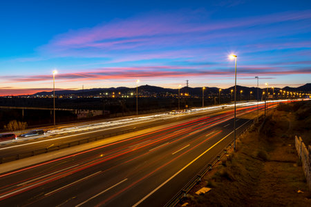 Freeway at dusk, two-way traffic with light trails.