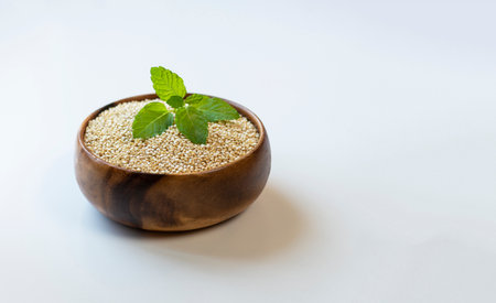 wooden bowl filled with quinoa on white backgroundの写真素材