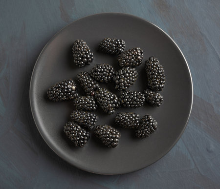 Dish with blackberries black on rustic background. top viewの写真素材