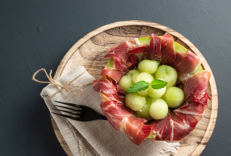 melon with air dried ham, rustic background with copy space. top viewの写真素材