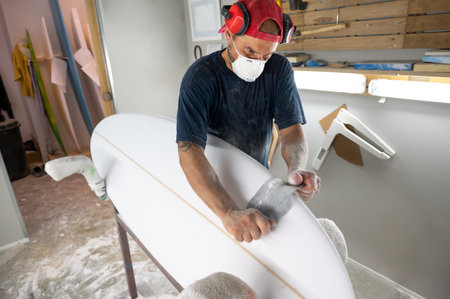 Surfboard Modeling Workshop - Man perfecting the modeling of a surfboardの写真素材