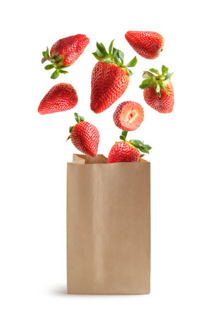 Flying strawberries, recyclable paper bag, isolated from the white backgroundの写真素材