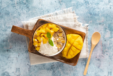 Cereal bowl with mango and yogurt, top view