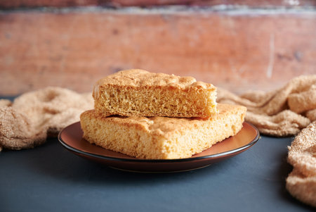 Delicious freshly baked sponge cake on a plate. Rustic background