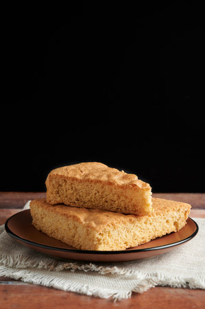 Delicious freshly baked sponge cake on a plate. Black background with space for copy