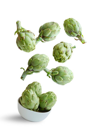Flying artichokes in a bowl isolated from the white backgroundの写真素材