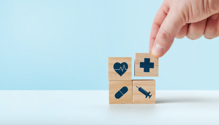 Health insurance concept, hand holding a wooden cube with medical health iconsの写真素材