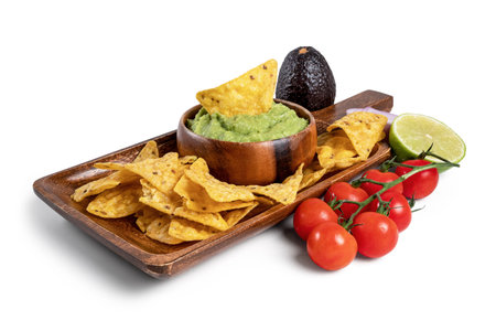 A wooden board with guacamole sauce, nachos and ingredients isolated from the white backgroundの写真素材