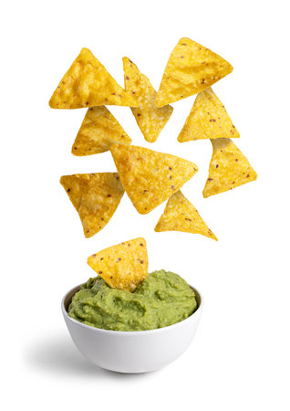 Nachos falling on a bowl with guacamole isolated on the white backgroundの写真素材