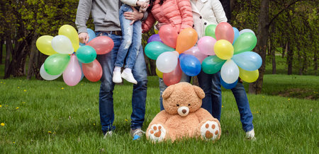 Legs in family gym shoes close-up with balloons on holidayの写真素材