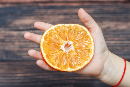 Piece of orange in handの写真素材