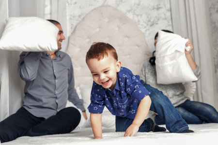 family playing with pillows on the bedの写真素材