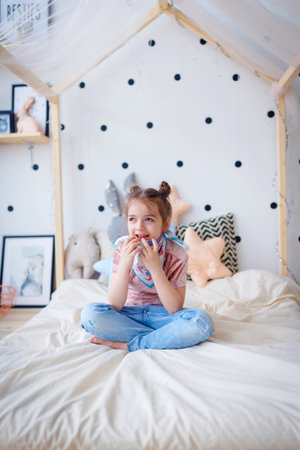 Cute little girl thoughtful in bedの写真素材