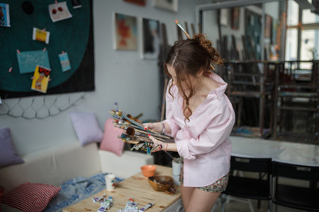 Female Artist Working On Painting In Studioの写真素材