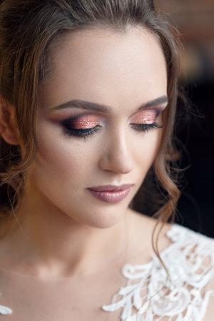 Side view of gorgeous brunette girl posing at studio. Wedding makeup close-up.の写真素材