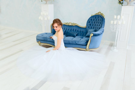 Beautiful young bride in a luxury dress in elegant interioの写真素材