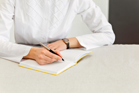 close up doctor writes in notebook