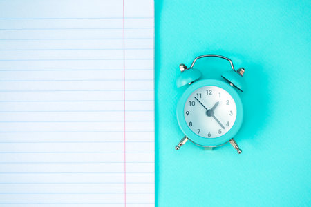 Blue alarm clock, scheduler on a blue background. The concept of time planning. Close-up. Empty...