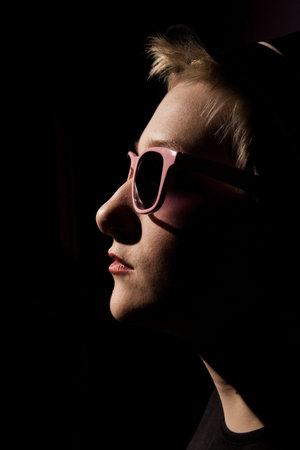 rock star in the dark in pink glasses in the profile