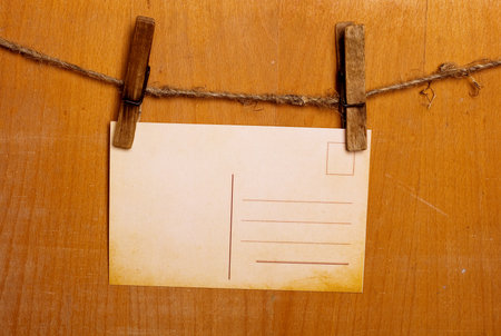 postcard on a pin on wooden backgroundの写真素材