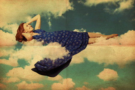 beautiful young woman in clouds in the skyの写真素材