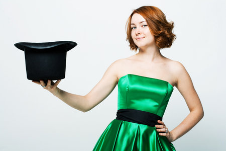 portrait of beautiful young woman with hat in green dress , studio shootingの写真素材