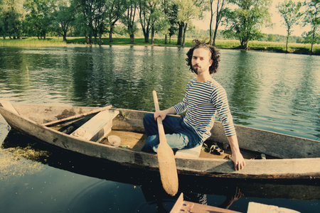 art image with handsome man in boatの写真素材