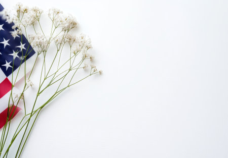 A vibrant American flag rests gracefully alongside delicate white flowers, symbolizing unity and patriotism in a serene setting.の素材