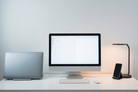 A stylish workspace showcases an iMac and MacBook alongside a smartphone, blending functionality with contemporary aesthetics.の素材
