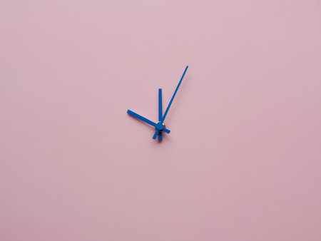 A striking blue clock stands alone against a soft pink background, showcasing simplicity and elegance in design, inviting contemplation of time.の素材