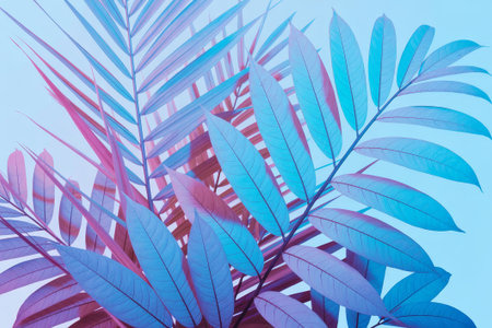 Colorful palm leaves stand out vividly against a blue backdrop, showcasing intricate patterns and textures. The blend of colors adds a lively touch to the scene.の素材