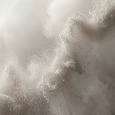 Fine particles of concrete dust swirl gently in the air, catching light and creating an ethereal atmosphere at a construction site.の素材