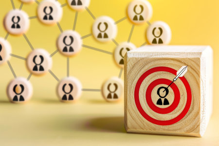 Wooden block with a target icon connected to human icons, representing the concept of customer focus in Customer Relationship Managementの素材