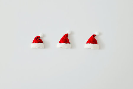 A joyful display of three red and white Santa hats side by side, evoking the warmth and cheer of Christmas celebrations.の素材