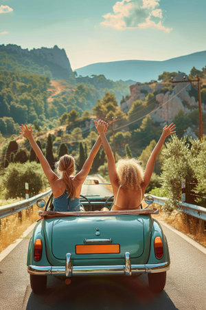 Arms raised in delight, two friends revel in the freedom of an open-road adventure against a backdrop of warm sunset huesの素材