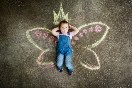 Little Fairy girl surprise drawing with chalk on the pavementの写真素材