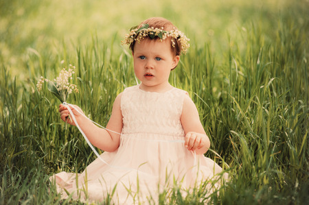 beautiful little girl in wreath of flowersの写真素材