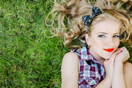 Happy Girl blonde smiling lying on the grassの写真素材