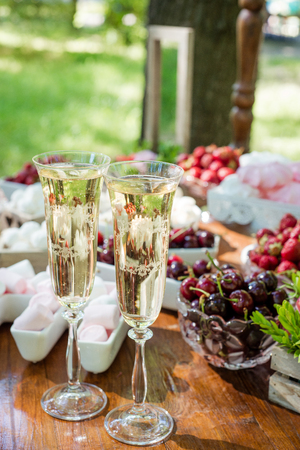Festive table setting wineglasses with champagne, fruit and marshmallows. Wedding decor.の写真素材