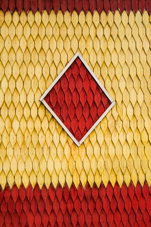 Old weathered wooden wall with ornament painted in red and yellow. Vintage texture Background.の写真素材