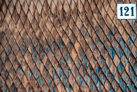 Old weathered wooden wall with ornament painted in brown and blue. Vintage texture Background.