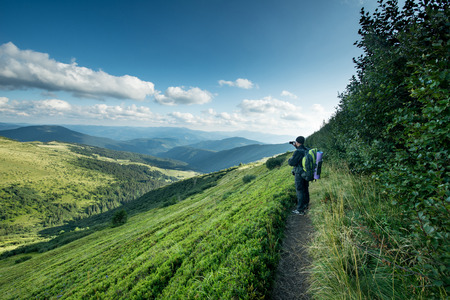 Traveler with backpack and smartphone on the mountainsの写真素材