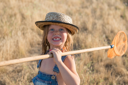 Smiling child with butterfly netの写真素材