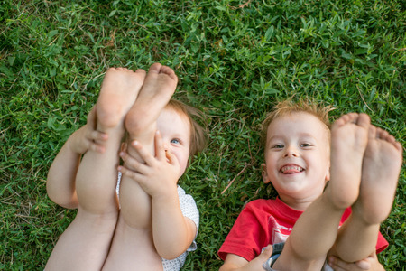Two children playing on the green lawn